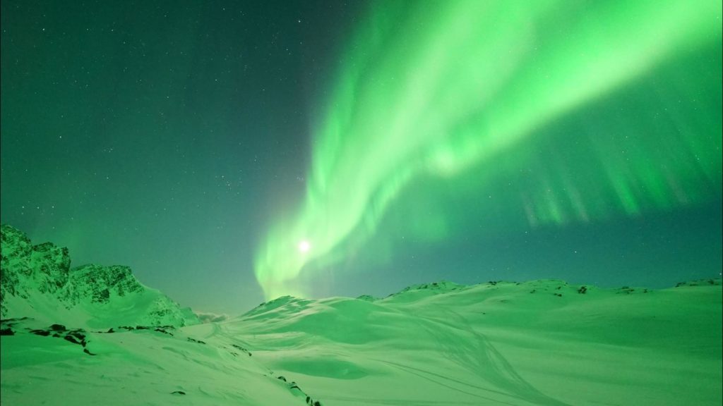 Landscape lit by moon and aurora